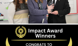 Three individuals posing with an award in front of a classroom board.